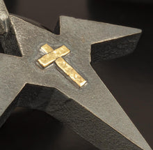 "Perspective shot of a unique two-tone cross jewelry piece, highlighting the sharp architectural lines and artisan craftsmanship