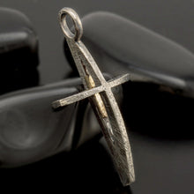 Detailed shot of the solid 14k gold cross suspended within an oxidized silver frame.