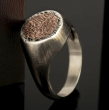 Front view of a handmade sterling silver signet ring with a textured copper inlay for men.