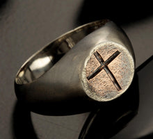 Front view of a rustic sterling silver signet ring with a copper top featuring a hand-engraved cross.