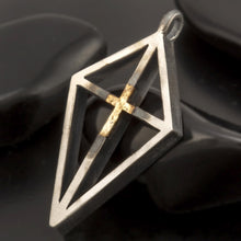 Two-tone silver and gold religious pendant on a dark background, showing the polished finish