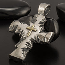 Close up of the artisan hammered texture and oxidized silver finish on a religious cross pendant