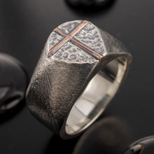 Handmade Viking-style RS-1425 ring on dark natural stones, emphasizing its ancient warrior aesthetic.