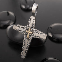 The P-177 handmade cross necklace resting on black stones, highlighting its ancient yet modern aesthetic.