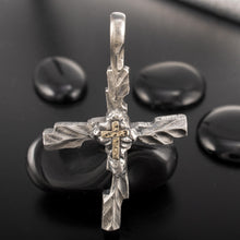 The P-178 silver and gold cross pendant held in hand to show its actual size and masculine proportions.