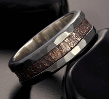 A man's hand wearing the wide textured mixed metal band, showcasing its bold presence